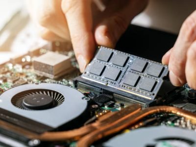 technician installing ram memory module in laptop motherboard. computer upgrade