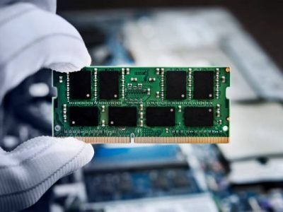 Hand with memory on a computer motherboard. RAM in hand on the background of the laptop.